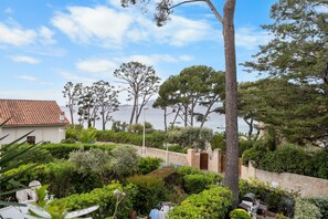 A coastal property with a white building, a stone wall, and a view of the sea.