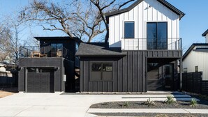 A modern two-story house with a garage, a balcony, and a small garden area. - Newly Built Home in Central Austin- 10 mins to downtown.  (Austin)