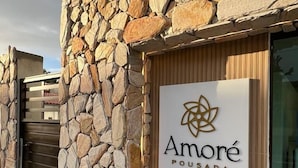 A stone facade with a sign for 'Amore Pousada'. - Pousada Amoré (Ipojuca)