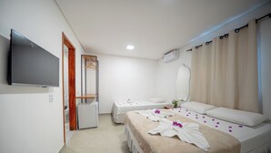 A hotel room with two beds, a TV, a mirror, an air conditioner, and a shower area. - Pousada Amoré (Ipojuca)