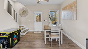 A dining area with a wooden table and chairs, a ceiling fan, and a painting on the wall. - Mtn Views, 20 Mins to Asheville, 12 Mins to Skiing, Arcade Games (Mars Hill)