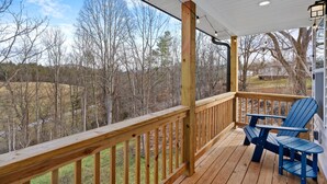 A wooden deck with a railing, two Adirondack chairs, and a view of a forested area. - Mtn Views, 20 Mins to Asheville, 12 Mins to Skiing, Arcade Games (Mars Hill)