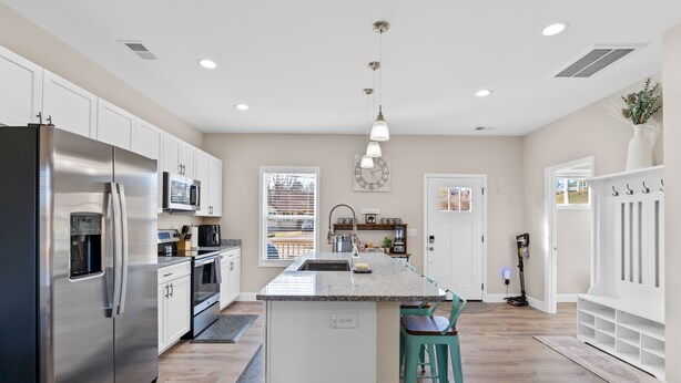 A spacious kitchen with a central island, stainless steel appliances, and a view to the backyard. - Mtn Views, 20 Mins to Asheville, 12 Mins to Skiing, Arcade Games (Mars Hill)