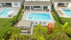 A residential property with a central swimming pool, a covered patio, and a separate pool area. - House Resort at Encore Reunion - Disney (Kissimmee)