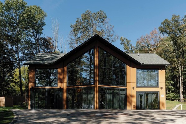 A modern building with large windows and a wooden exterior. - Lakefront Mansion / Exclusive SPA, Fishing, Lake (Pocono Township)