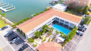 Ein Hotel mit Schwimmbad, Parkplatz und Blick auf das Wasser.