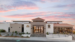 A modern building with a restaurant named 'DesCatalo Sunset' and a bar named 'Barbwire Place'. - Voyage Vacation Club (Playas de Rosarito)