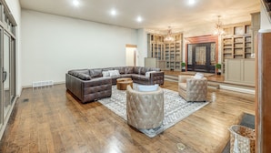 A spacious living room with a sectional sofa, ottomans, and a fireplace.