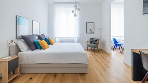 Une chambre à coucher moderne avec un grand lit, un bureau et une chaise.