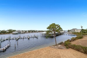 A waterfront property with docks, a covered boat house, and a sandy beach area. - Cotton Bayou 8C | Waterfront | Boat Slip & Launch | Pool | Beach Getaways (Orange Beach)