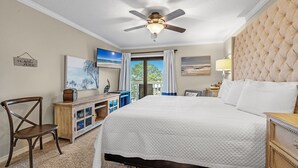 Ein Hotelzimmer mit einem großen Bett, einem Deckenventilator, einem Fernseher und Blick ins Freie.