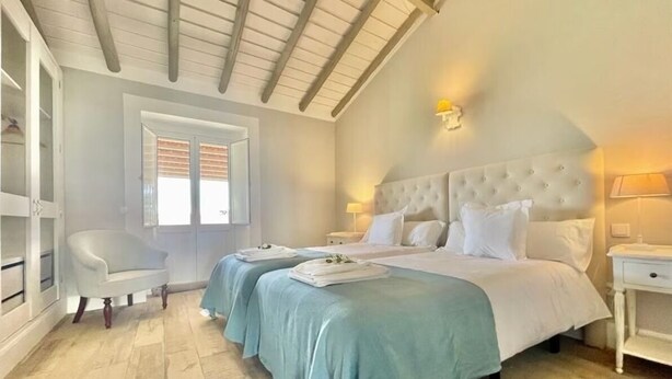 A bedroom with two beds, a chair, and a wardrobe. - Villa HERDADE DA BOAVISTA: 1.000 sqm house just for YOU! Capacity: 20 guests. (Aljustrel)