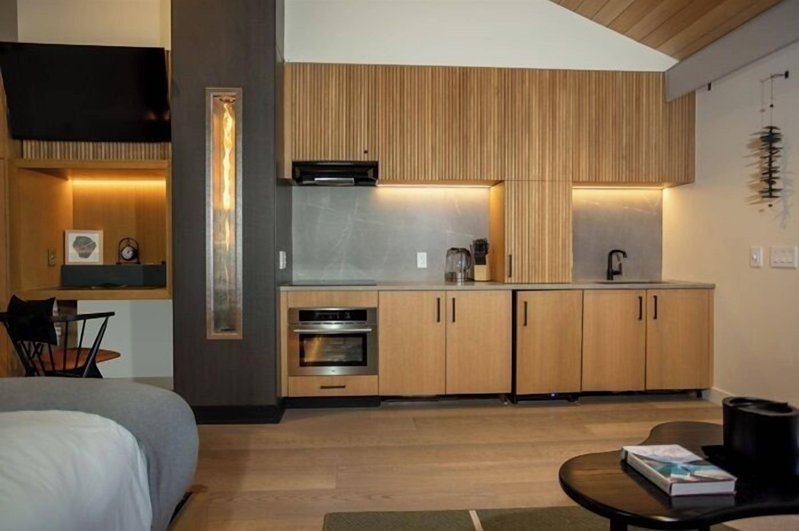 A compact kitchen with wooden cabinets, a built-in oven, and a microwave.