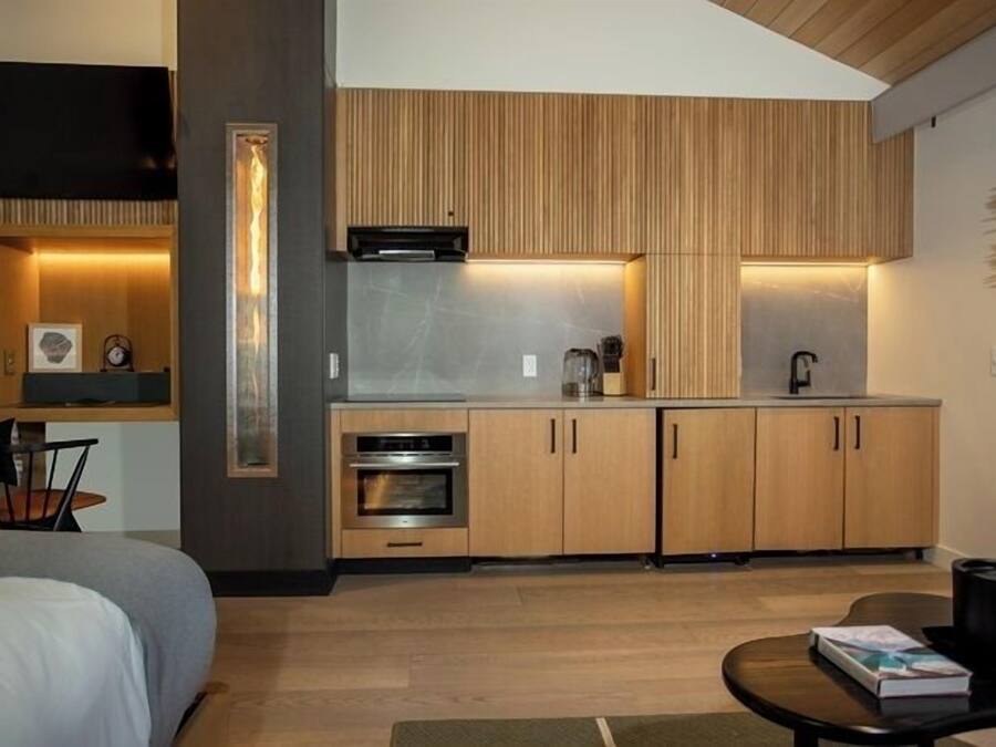 A compact kitchen with wooden cabinets, a built-in oven, and a microwave.