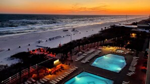 Ein Resort mit Poolbereich, Strandzugang und Blick auf den Sonnenuntergang.