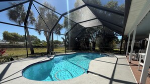 Une piscine couverte avec un bassin aux eaux d’un bleu limpide, entourée d’une terrasse en béton et protégée par une enceinte en verre.
