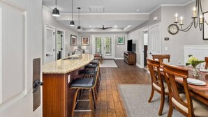 A spacious kitchen with a central island, bar stools, and a dining area with wooden chairs. - Perfect Golfer’s 4 bed/4 bath Condo at TPC, M.B. (Murrells Inlet)