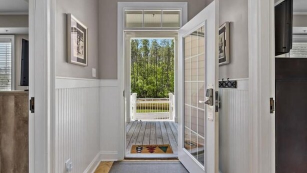 A hallway leading to a deck with a view of trees. - Perfect Golfer’s 4 bed/4 bath Condo at TPC, M.B. (Murrells Inlet)