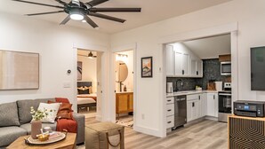 Een modern appartement met woonkamer, kitchenette en een slaapkamer.