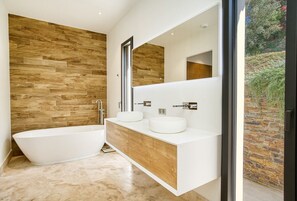 A modern bathroom with a freestanding bathtub, two sinks with round mirrors, and a wooden wall. - 5 bedroom accommodation in La Garde-Freinet (La Garde-Freinet)