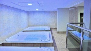 Un espace bien-être comprenant trois bains à remous et une rambarde en verre.