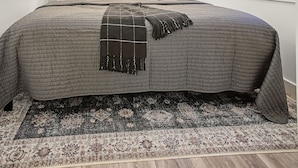 Un dormitorio con cama, ventilador de techo, ventana con persiana y aire acondicionado de pared.