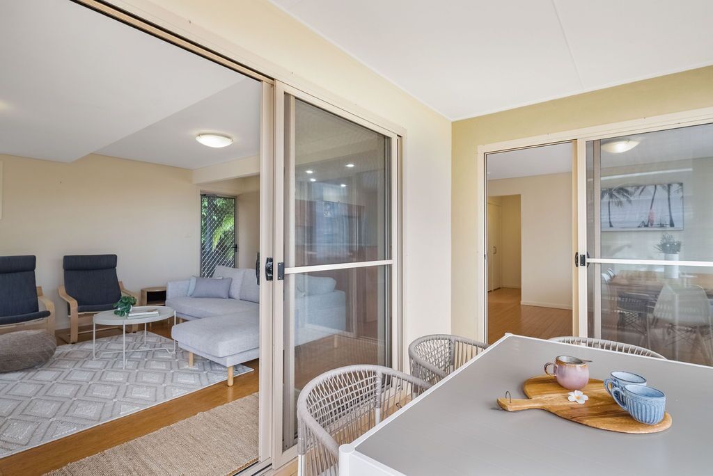 Un salon moderne comprenant un canapé, deux fauteuils, une table basse et une table à manger avec un plateau.
