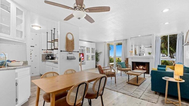 A spacious living area with a wooden dining table, chairs, a sofa, and a fireplace. - Amazing Ocean Views-Walk Out Beach Access - Spacious living room area- North Coast Village G35 (Oceanside)