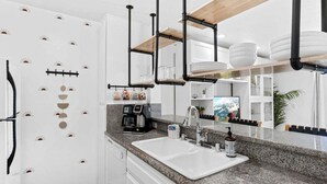 A modern kitchen with a granite countertop, white cabinets, and a built-in dishwasher. - Amazing Ocean Views-Walk Out Beach Access - Spacious living room area- North Coast Village G35 (Oceanside)