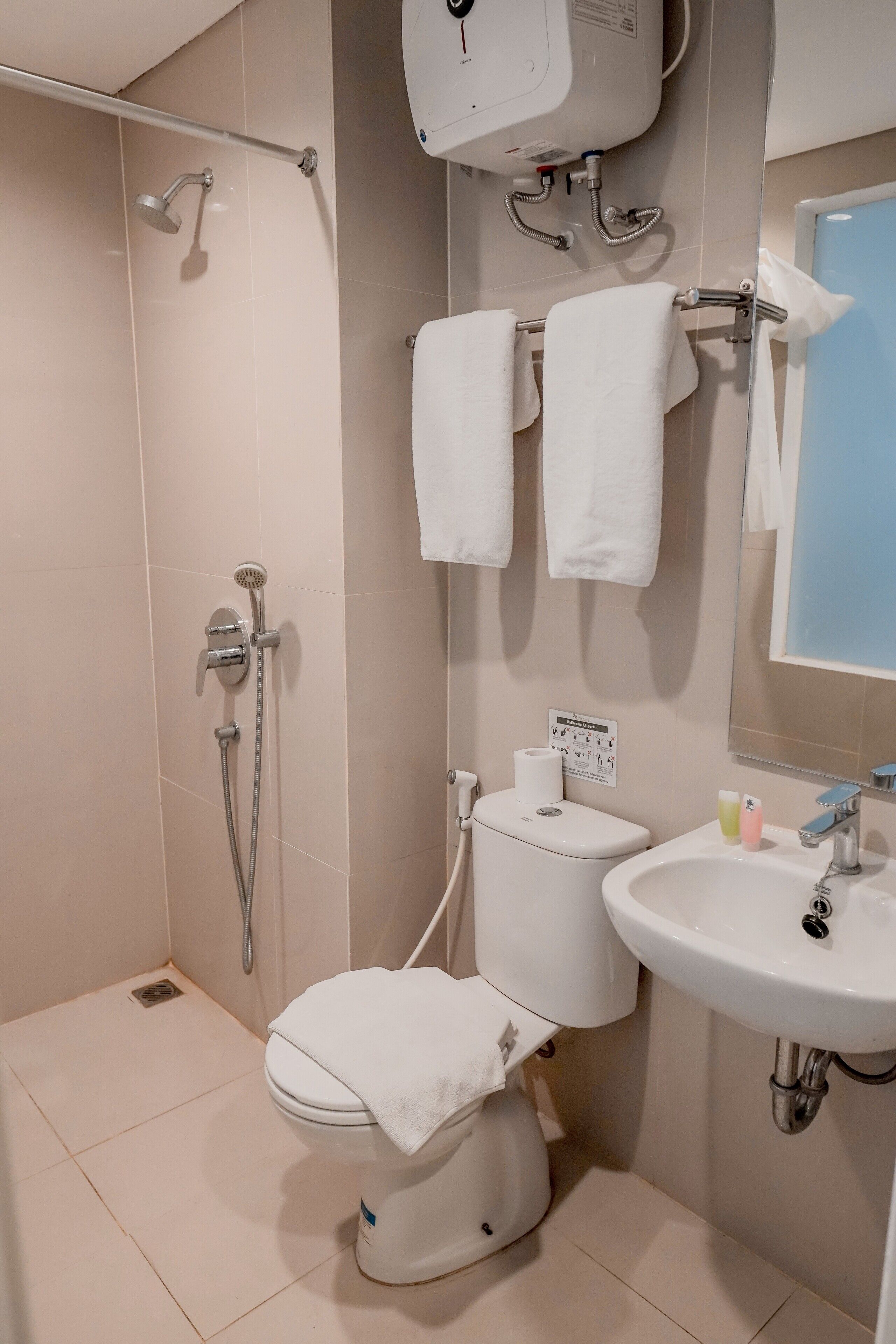 Une salle de bain comprenant des toilettes, un bidet, une douche et un lavabo.