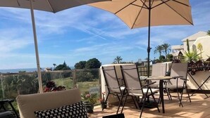A terrace with a sofa, chairs, a table, and an umbrella. - 2 Bed Flat-Sleeps4-Pets-Pool-Parking-GolfClub (Estepona)