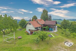 Una casa con un jardín amplio, un columpio y una mesa de picnic.