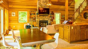 A cozy cabin interior with a dining area, kitchen, and living space.