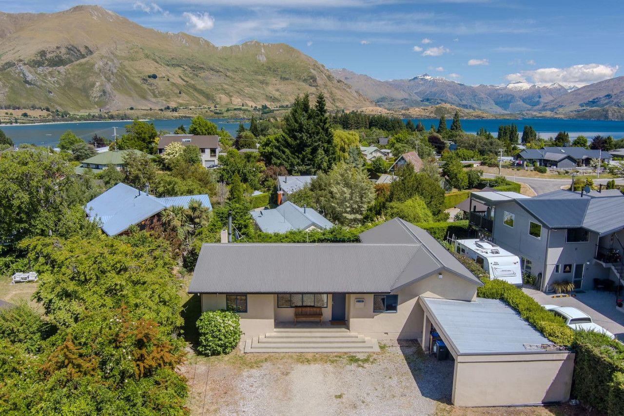 A residential area with houses, a lake, and mountains in the background.