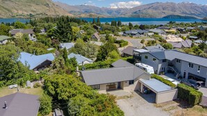 A residential area with houses, a lake, and mountains in the background. - Terrific views on Totara (Wānaka)