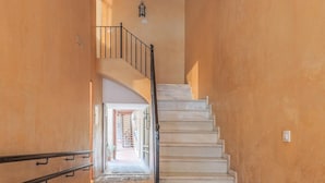 Un escalier avec une rampe, menant à un palier doté d’une porte.