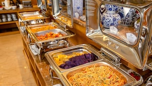 A buffet with various food options including pasta, fruits, and other dishes. - TGT BEACH HOTEL (Da Nang)