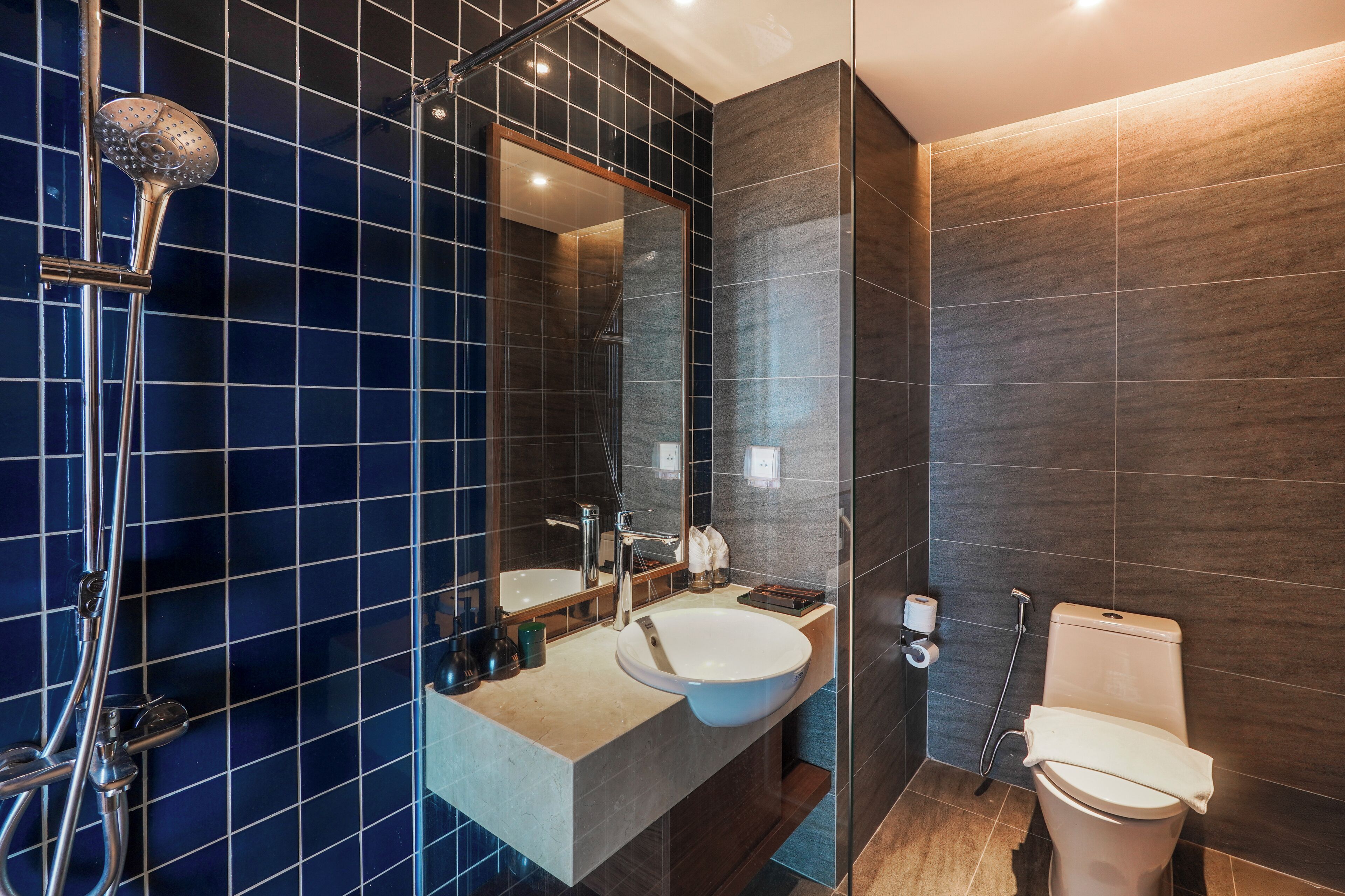 Ein modernes Badezimmer mit einem großen Spiegel, einem Waschbecken und einer Dusche.