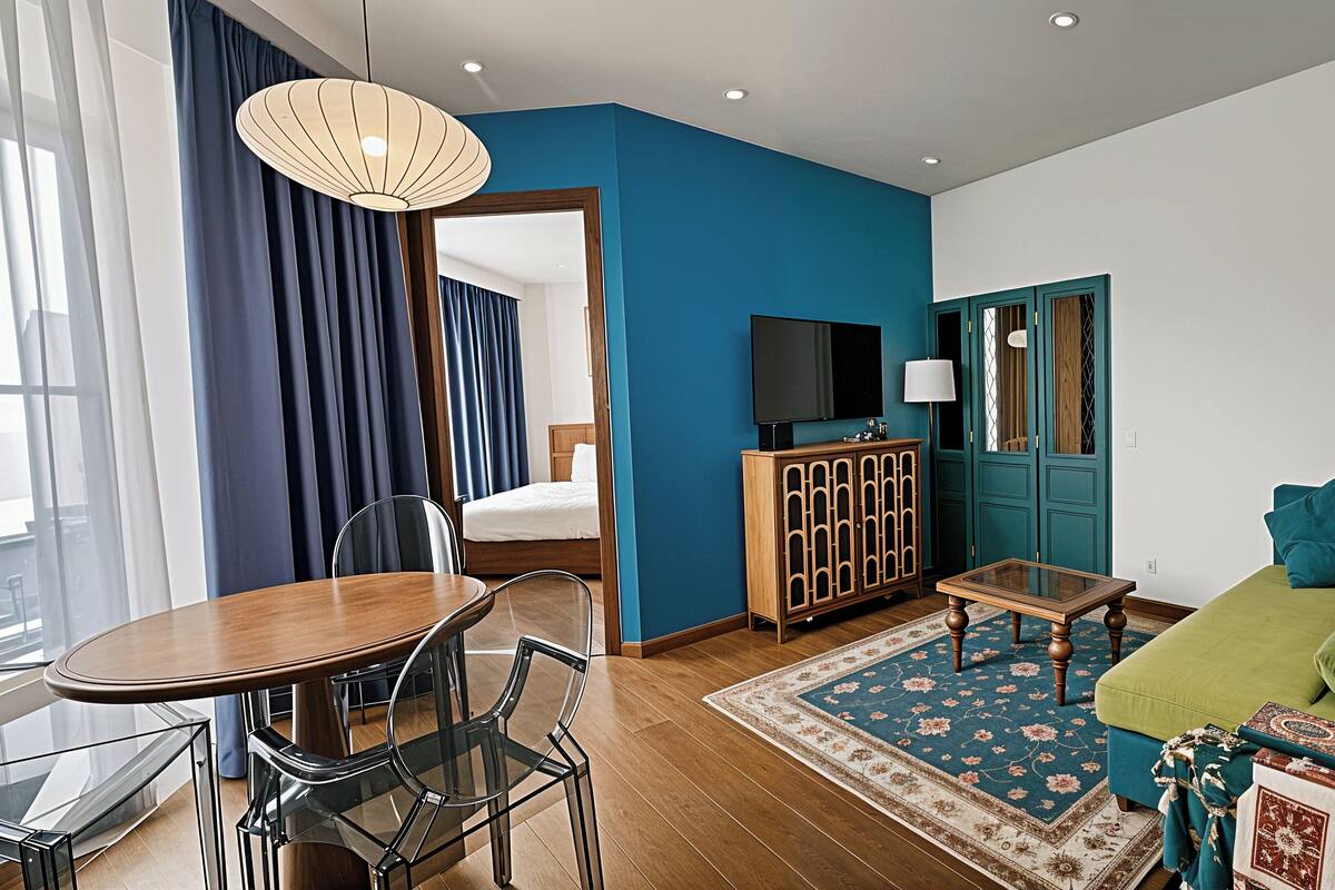 A modern living room with a dining area, a sofa, a TV, and a wooden cabinet.