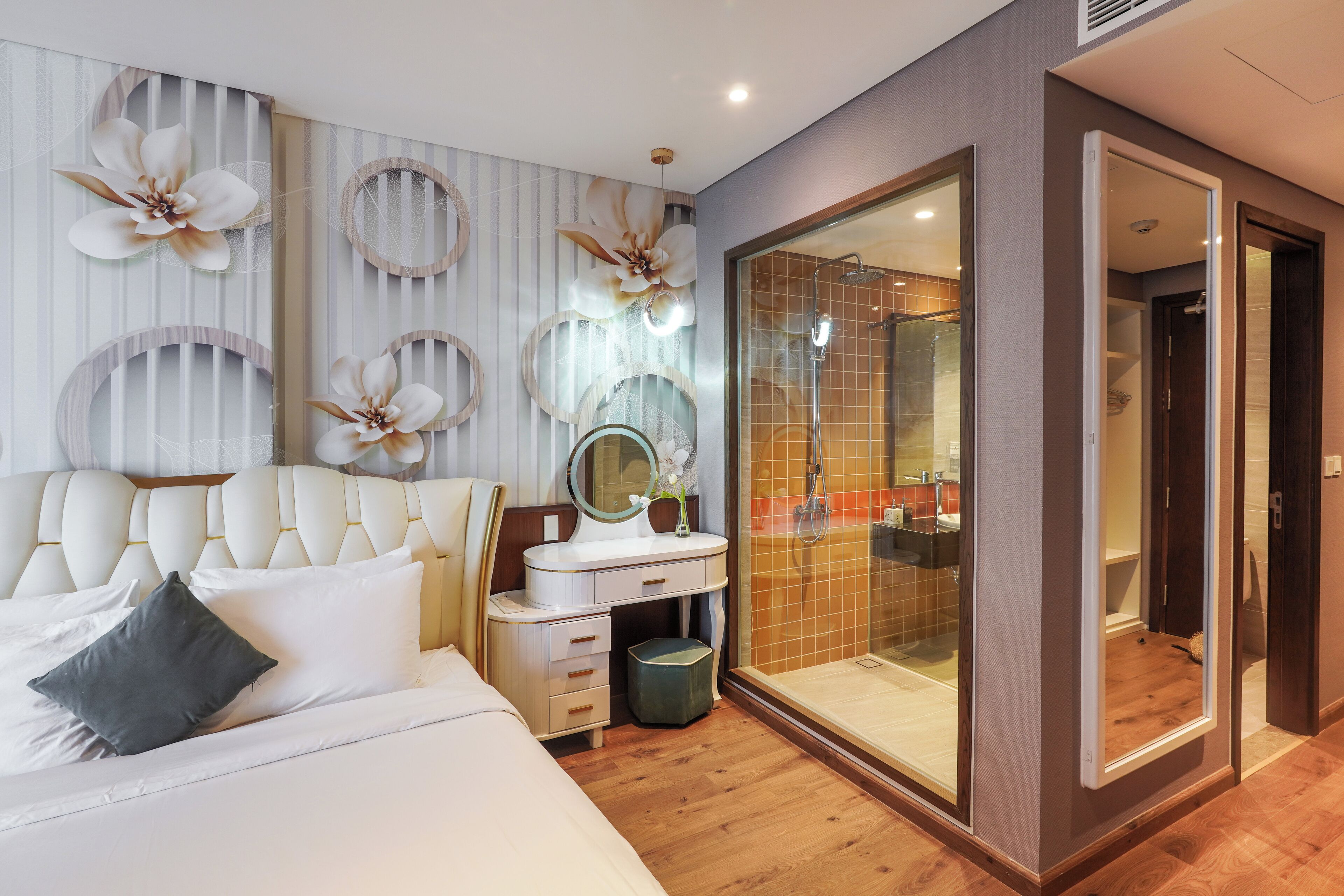 Un dormitorio moderno con una cama grande, un tocador con espejo y un vestidor.