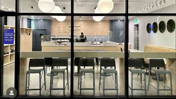 Ein modernes Interieur mit Küchenzeile, einer Bar und einer Sitzecke mit Stühlen.