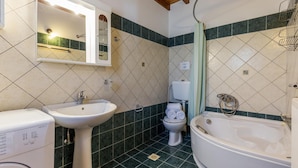 Et badeværelse med vask, toilet og badekar.