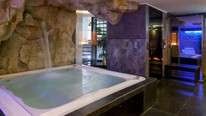 Un espace spa comprenant un bain à remous, une cascade et un comptoir d’accueil.