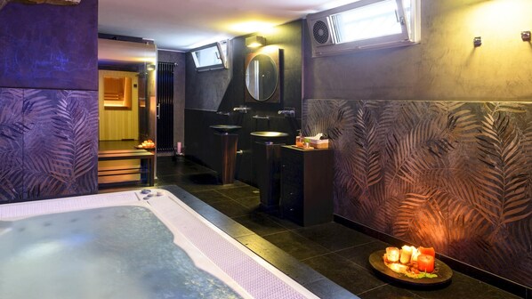 Ein Spa-Raum mit einer großen Badewanne, zwei Waschbecken und einem Spiegel.