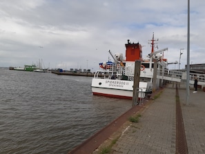 A docked ferry named SPIEKEROOG II at a port with a pedestrian walkway.