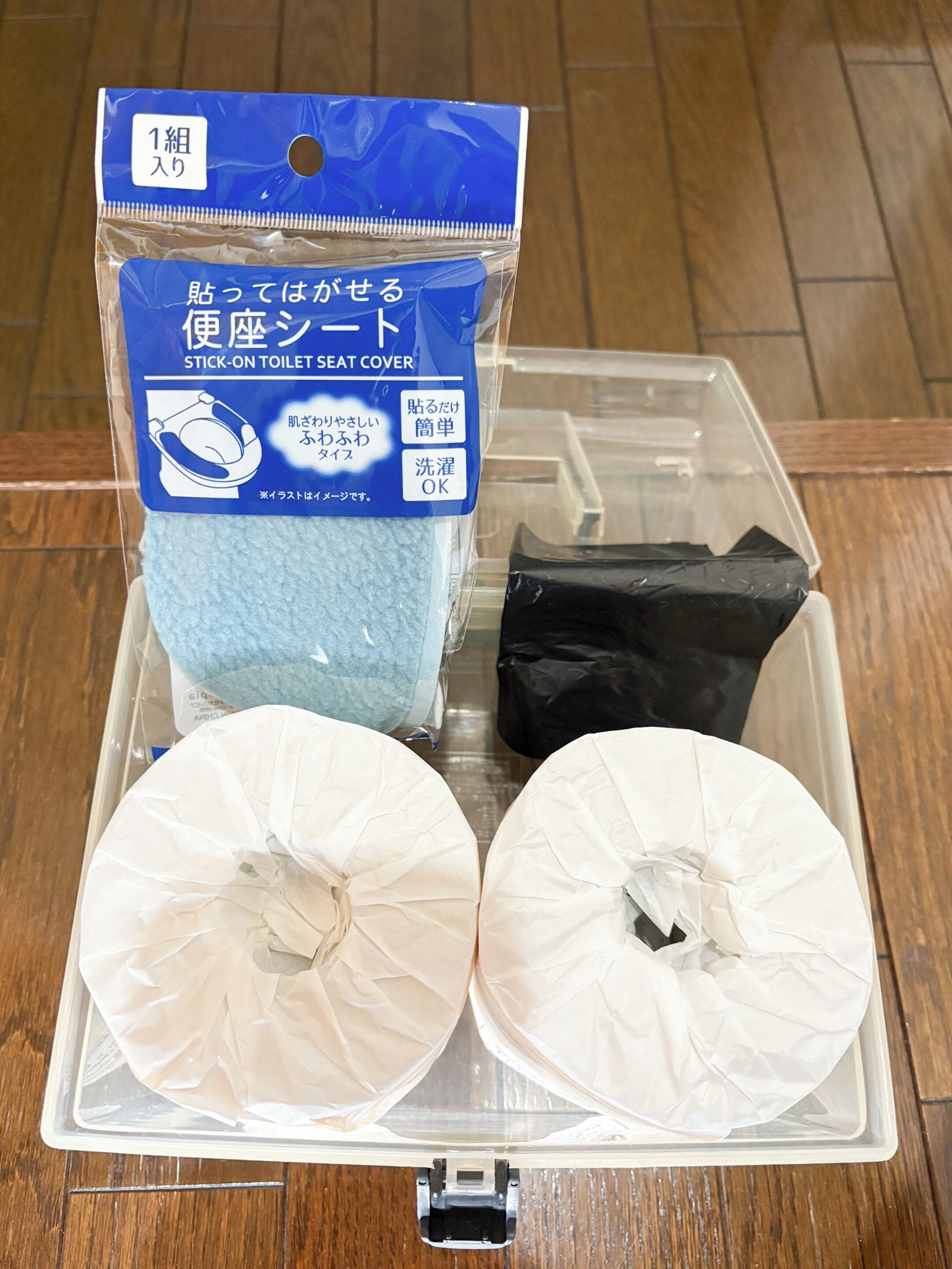 A plastic container with a blue label and two white toilet seat covers.