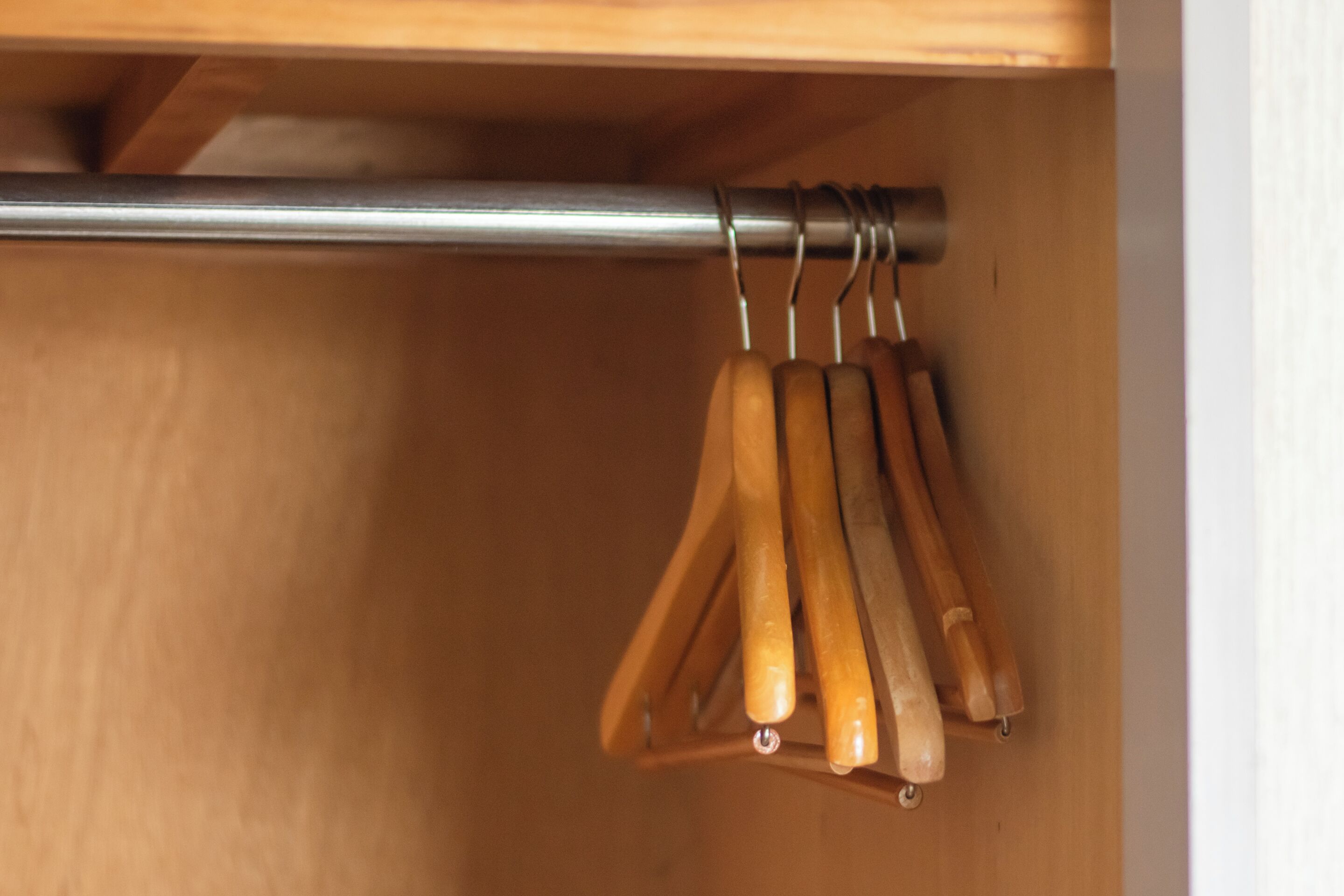 A wooden drawer with a metal rod and wooden handles.