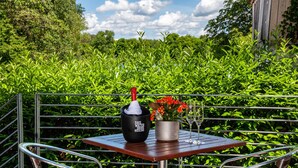 Ein Tisch mit einer Flasche, einem Glas und einem Blumentopf.