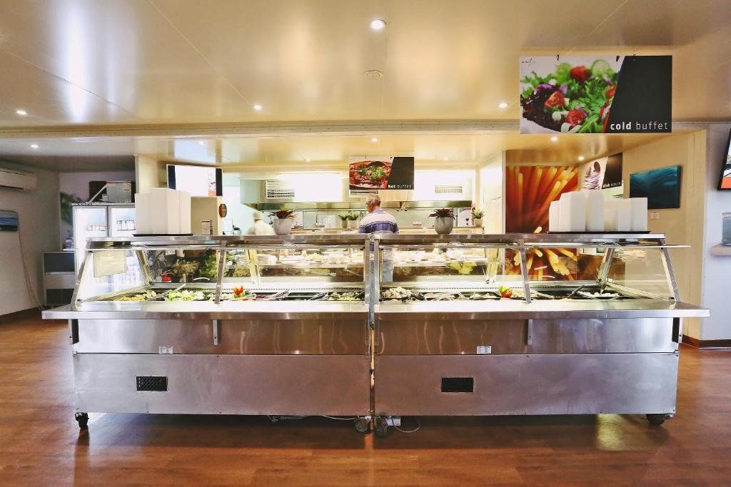 Zona de buffet amb diverses vitrines expositores de menjar i un cartell que indica la secció de buffet fred.