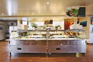 A buffet area with multiple food display cases and a sign indicating a cold buffet section. - Capricorn Village (Capricorn)